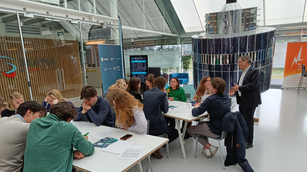 students working on a technology transfer case in the atrium of SBIC Noordwijk by the satellite